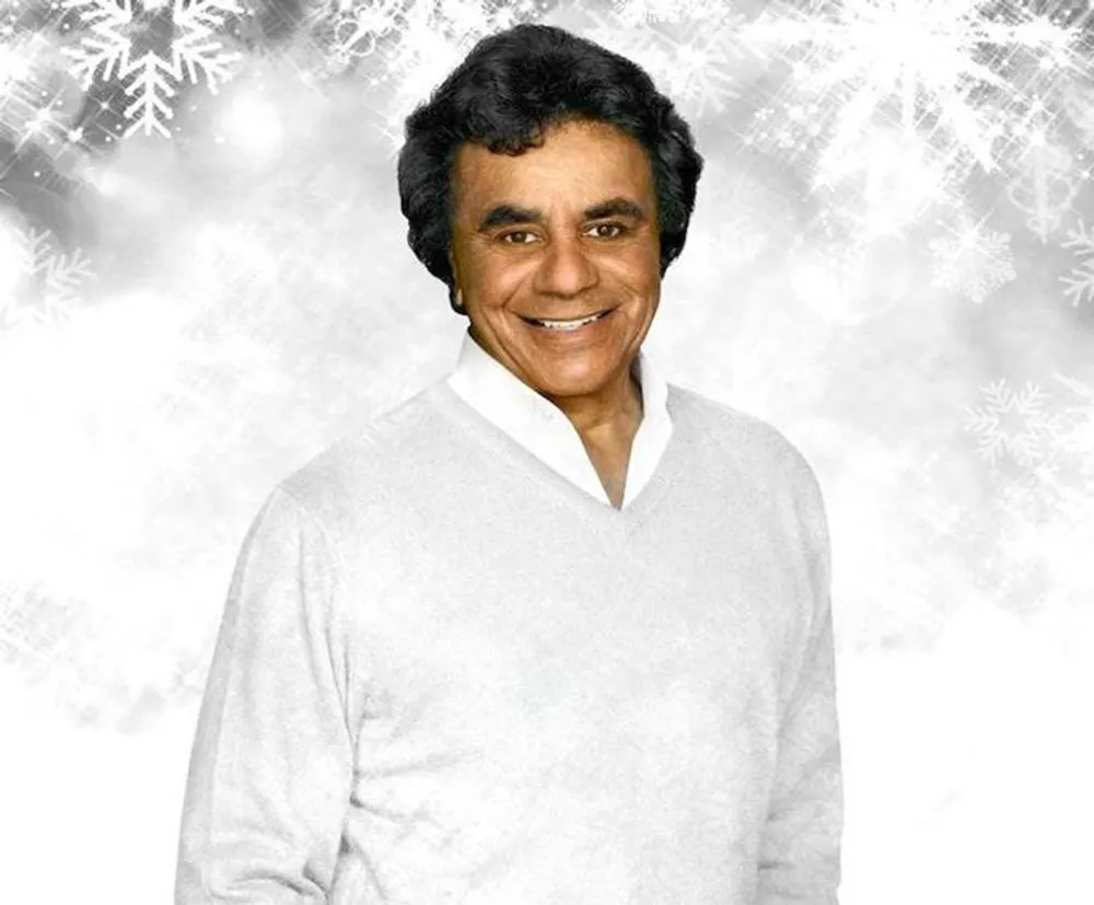The image depicts a smiling person in a white sweater set against a festive background with snowflakes