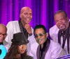 This is a digitally altered image featuring a montage of various people seemingly performers with a backdrop of purple stage curtains and spotlights