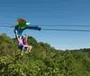 A man and a woman are smiling and enjoying a chairlift ride over a body of water surrounded by lush greenery