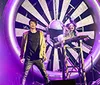 A dramatic scene features two performers in front of a large fan with sparks flying promoting an unexplainable magic show with logos of major TV networks at the bottom