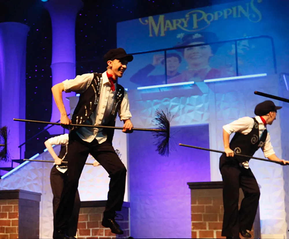 Performers dressed as chimney sweeps are engaged in a lively stage number during a production of Mary Poppins