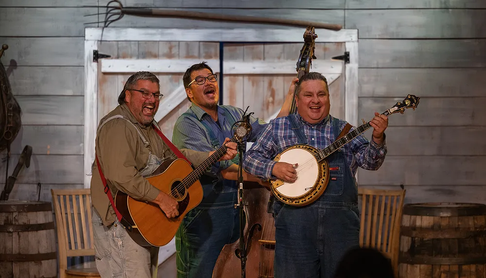 Three musicians are joyfully performing onstage with acoustic instruments including a guitar a double bass and a banjo